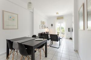 a dining room and living room with a table and chairs at Central Park View Apartment in Thessaloniki