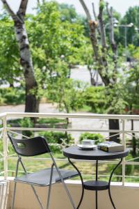a table and a chair sitting on a balcony at Central Park View Apartment in Thessaloniki