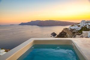 a swimming pool on top of a house with the ocean at Kaleidoscope Cave Houses in Oia
