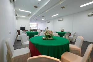 a conference room with green tables and white chairs at The Leverage Business Hotel - Bandar Baru Mergong in Alor Setar