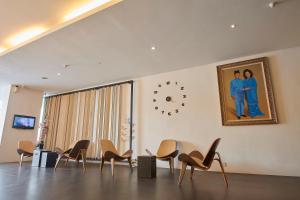 a room with chairs and a clock on the wall at The Leverage Business Hotel - Bandar Baru Mergong in Alor Setar