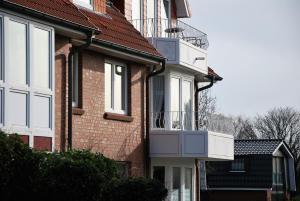 ein Backsteinhaus mit einem Balkon an der Seite in der Unterkunft Haus Nordseeperle Whg.5 in Cuxhaven