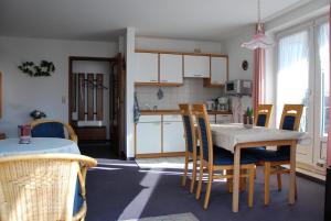 eine Küche und ein Esszimmer mit einem Tisch und Stühlen in der Unterkunft Haus Nordseeperle Whg.5 in Cuxhaven