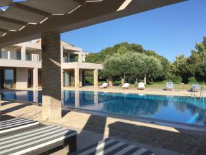 a villa with a swimming pool and a house at Villa Lefka in Kastrosikia