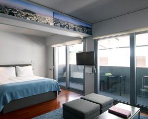 a bedroom with a bed and a balcony with a table at Periscope in Athens