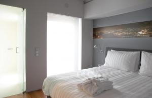 a bedroom with a white bed and white walls at Periscope in Athens