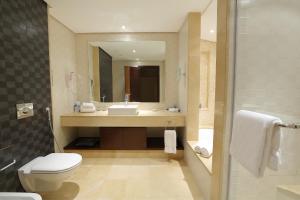 a bathroom with a toilet, sink, and bathtub at Corp Amman Hotel in Amman