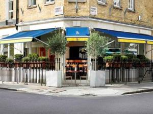 a store with a fence in front of a building at Julian apartment center of London in London