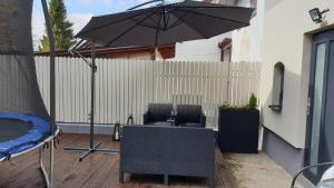 um pátio com um guarda-sol, uma mesa e cadeiras em Apartament TA3 em Veľký Slavkov
