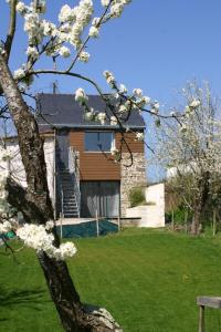 Una casa con un árbol con flores blancas. en Au gré du Marais - Chambres d'hôtes en Ancenis