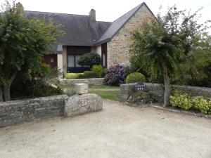 una casa con una pared de piedra y un cementerio en Villa d'Ys, en Châteaulin
