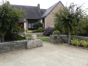 a house with a stone wall and a grave yard at Villa d'Ys in Châteaulin