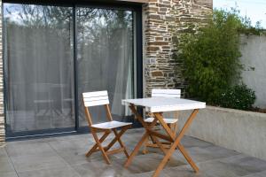 2 sillas y una mesa en el patio en Au gré du Marais - Chambres d'hôtes en Ancenis