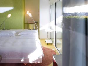 ein Schlafzimmer mit einem weißen Bett und einem Fenster in der Unterkunft Semiramis, a Member of Design Hotels in Athen + 78 Fotos