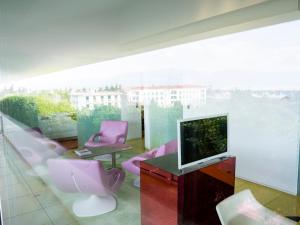 a living room with pink chairs and a television at Semiramis in Athens