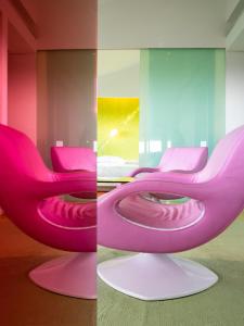dwa zdjęcia różowego krzesła w pokoju w obiekcie Semiramis w Atenach