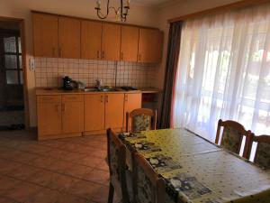 a kitchen with a table and chairs and a table and a table and a kitchen at Holiday Home Scamard in Zamárdi