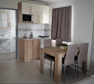 a kitchen with a wooden dining table and chairs at Blue Mediterran Apartment House in Balatonfüred