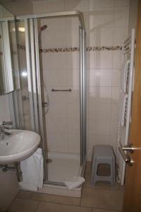 ein Bad mit einer Dusche und einem Waschbecken in der Unterkunft Appartementhaus Berlin in Bad Füssing