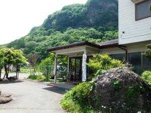 a building with a sign in front of a mountain at 布引観音温泉 in Ōhinata