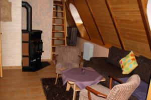 Ferienhaus auf der Kauperinsel في بورغ (سبريوالد): غرفة معيشة مع أريكة وموقد