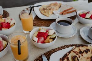 - une table avec des assiettes de produits pour le petit-déjeuner et des boissons dans l'établissement Rock'n Reef, à Uluwatu