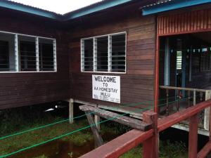una señal de bienvenida en el lado de una casa en AA Homestay, en Mulu
