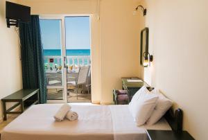 a hotel room with a bed and a view of the ocean at Birais Beach Studios in Rethymno