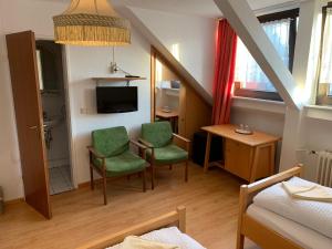 a small living room with two chairs and a table at Hotel Jeong in Moers