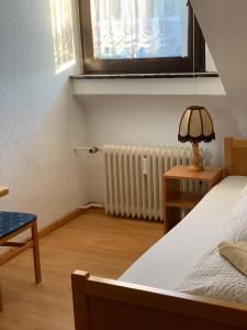 a bedroom with a bed and a window and a radiator at Hotel Jeong in Moers