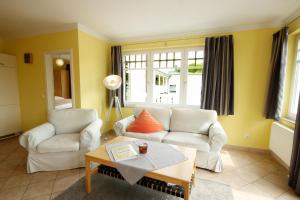 a living room with two white couches and a coffee table at Villa Laetitia by Rujana in Binz