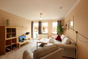 ein Wohnzimmer mit einem Sofa und einem TV in der Unterkunft Villa Laetitia by Rujana in Binz