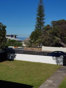 a retaining wall with grass and a car on it at Norfolkden Beachhouse in Hermanus