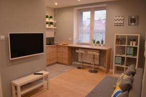 a living room with a tv and a desk at Apartament SZTOKHOLM in Białystok