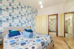 a bedroom with a bed with a polka dot wall at Sunset Holiday Home Taormina in Taormina