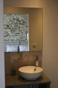 y baño con lavabo blanco y espejo. en Au gré du Marais - Chambres d'hôtes en Ancenis