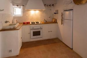 a kitchen with white cabinets and a white refrigerator at Can Toni Platera in Sant Francesc Xavier +18 photos