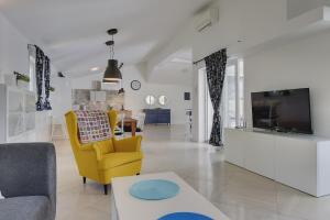 a living room with a yellow chair and a tv at Villa Sever in Labin