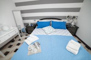 a bedroom with a blue bed with blue pillows at Peschici HOME FILOCCO stanza e bagno privato in Peschici