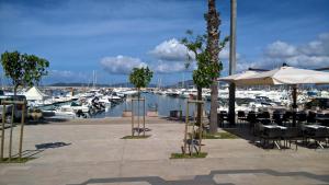 a marina with tables and chairs and boats in the water at Fleming 46 in Alghero