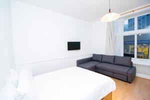 a bedroom with a bed and a couch and a window at Knightsbridge Apartments in London
