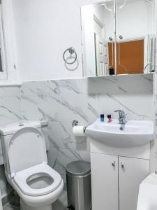 a bathroom with a white toilet and a sink at Knightsbridge Apartments in London