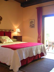 um quarto com uma cama com um cobertor vermelho e branco em Cappone B&B em Morciano di Romagna