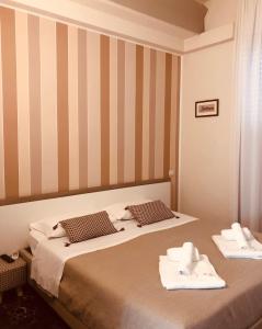 een hotelkamer met 2 bedden en handdoeken erop bij Emme B&B in Messina