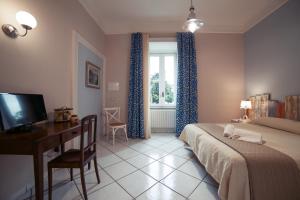 a bedroom with a desk and a bed and a window at La Tartaruga in Salerno