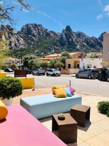 a blue couch with colorful pillows on a street at Locanda Sant'Andrea Hotel & Relais in San Pantaleo