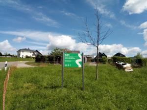 un panneau vert dans l'herbe à côté d'un arbre dans l'établissement ** Ferienwohnung im Weltkulturerbe nahe Loreley, à Niederburg