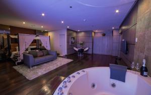 a large bathroom with a bath tub and a couch at One Manalo Place in Puerto Princesa City