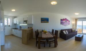 cocina y sala de estar con mesa y sofá en Apartment Sandra (2+2) with a breathtaking view en Vis