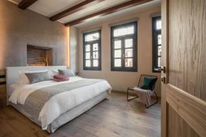 a bedroom with a large white bed and windows at J&G Suites in Chania Town +42 photos